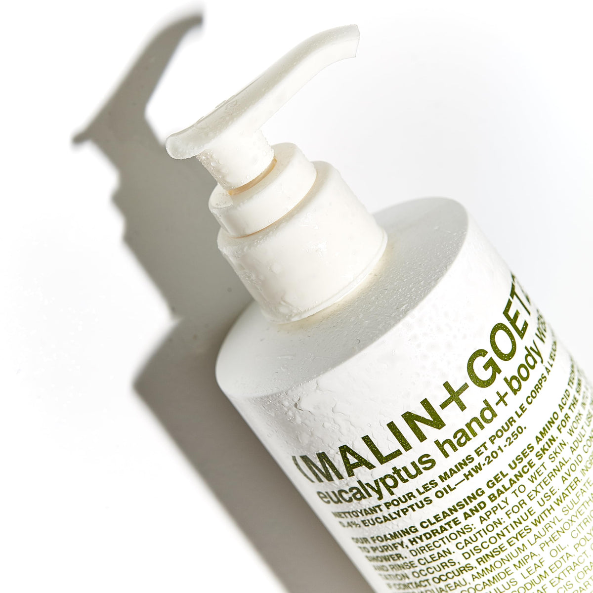 MALIN+GOETZ bottle in hand showing 8.5 fl oz size for travel and countertop benefit