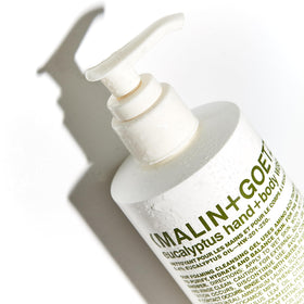 MALIN+GOETZ bottle in hand showing 8.5 fl oz size for travel and countertop benefit