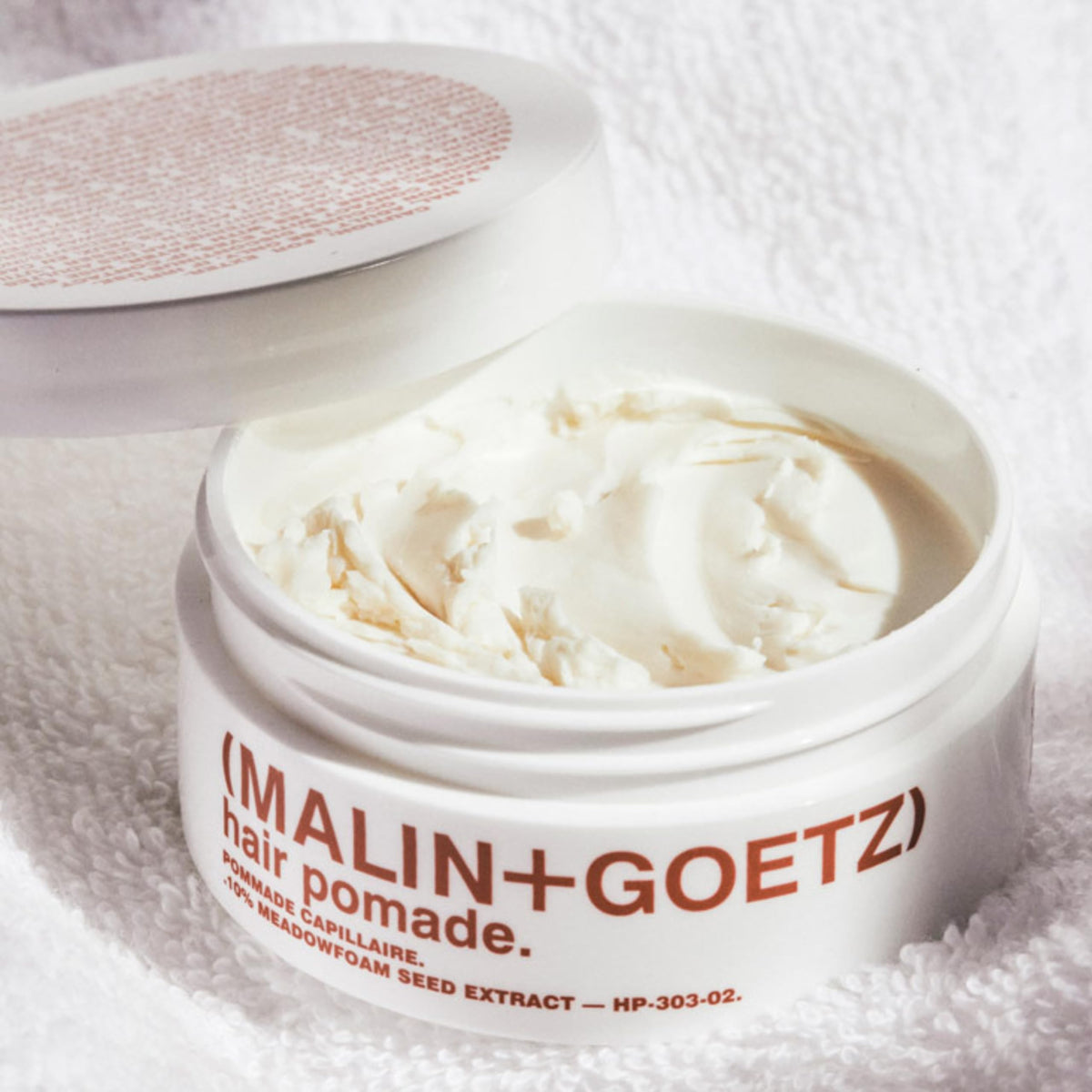 MALIN+GOETZ texture close-up revealing matte, firm paste consistency for structured styling