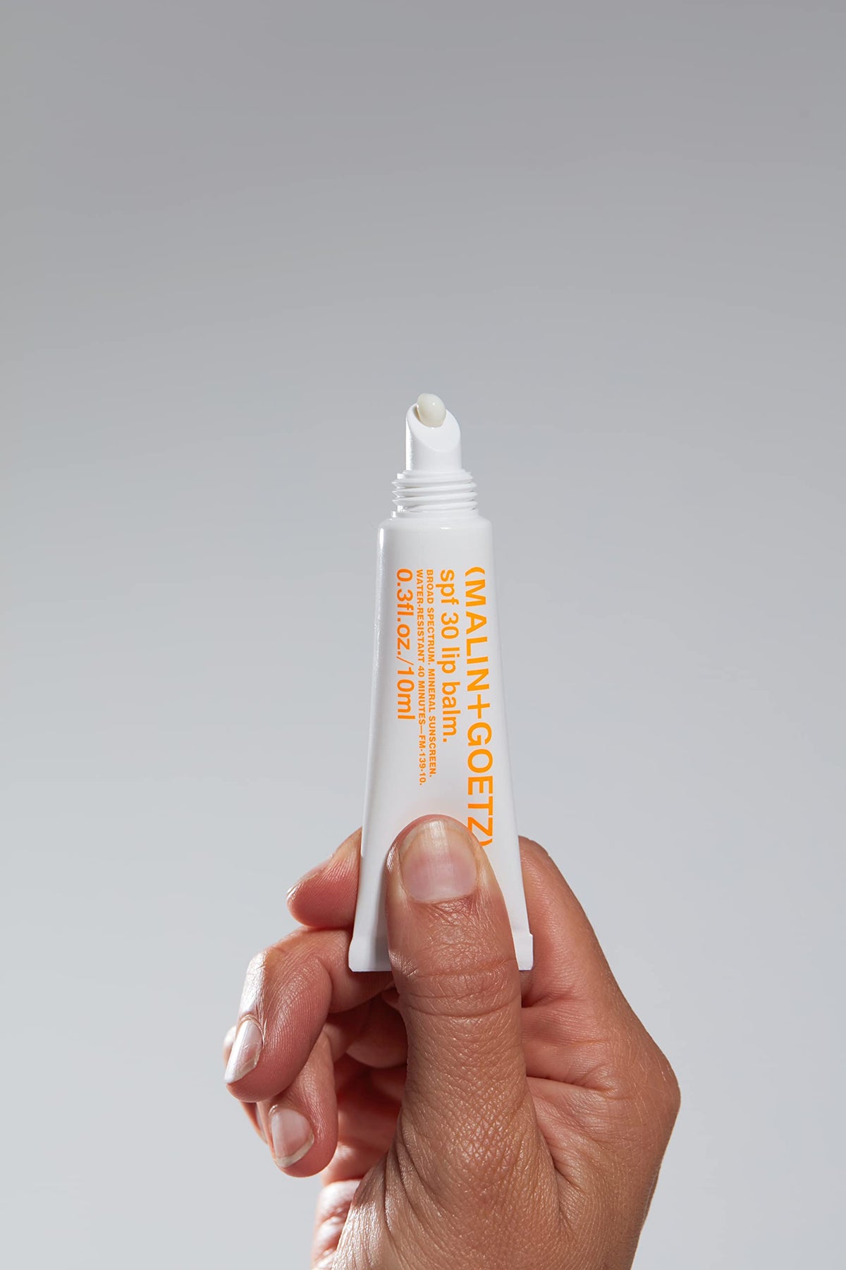 MALIN+GOETZ close-up of twist-up balm texture, smooth application benefit