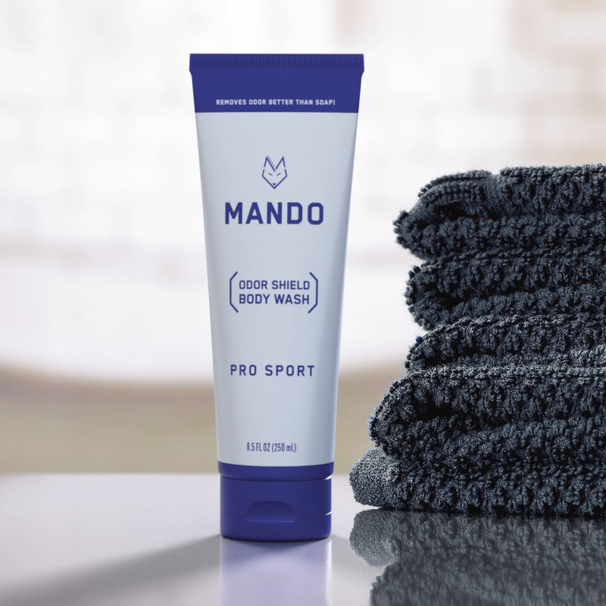 Mando bottle next to everyday items illustrating compact travel-friendly size