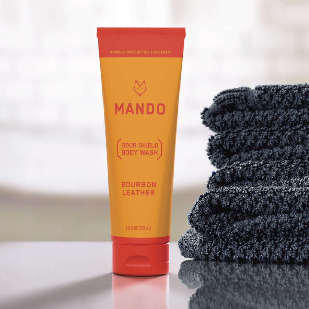 Mando bottle held in hand for scale showing compact 8.5 oz travel-ready size and portability