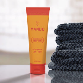 Mando bottle held in hand for scale showing compact 8.5 oz travel-ready size and portability