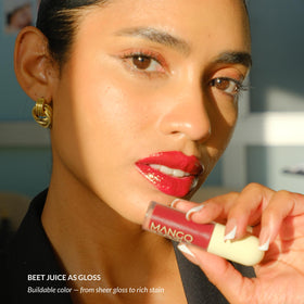 Mango People lip stain tube beside coin showing compact travel-friendly size