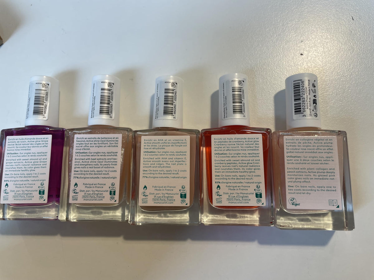 Manucurist bottles next to a ruler for scale to show compact, travel-friendly size