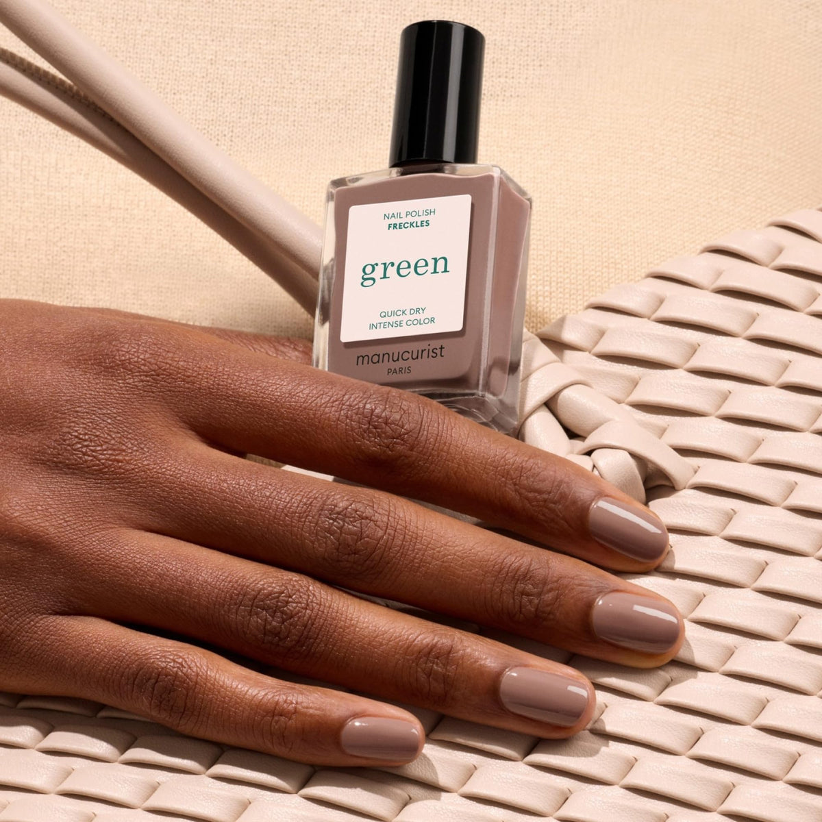 Manucurist Freckles swatch on hand illustrating cool-toned brown and versatile wear benefit