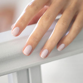 Manucurist Milky White swatch on fingertips showing sheer milky coverage and natural finish