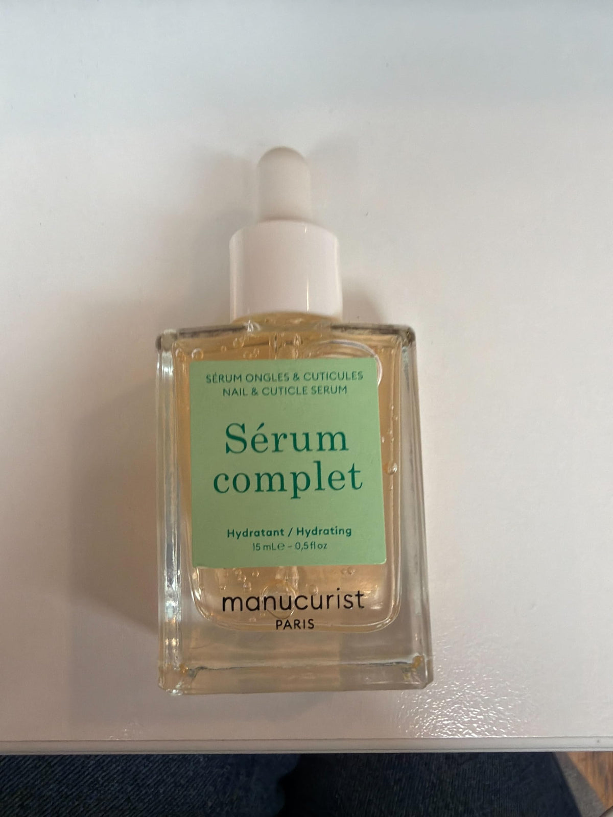 Hand next to Manucurist bottles to show product size and everyday use