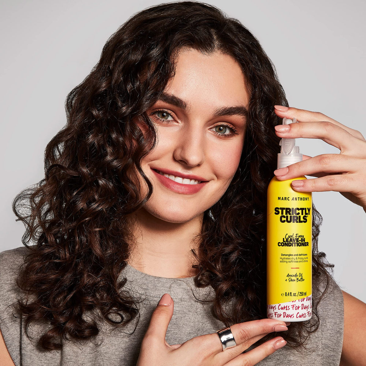 Marc Anthony lifestyle curly hair model showing hydrated, defined curls and natural bounce