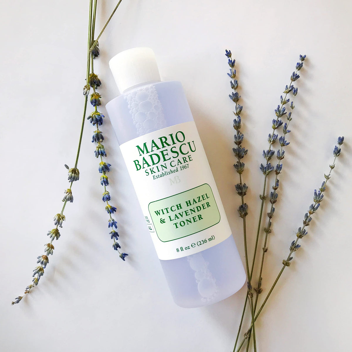 Mario Badescu bottle beside aloe leaves showing soothing ingredients