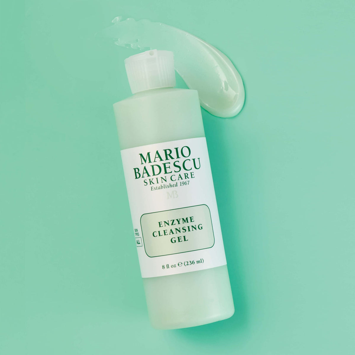 Mario Badescu 16 oz bottle next to common objects to show scale