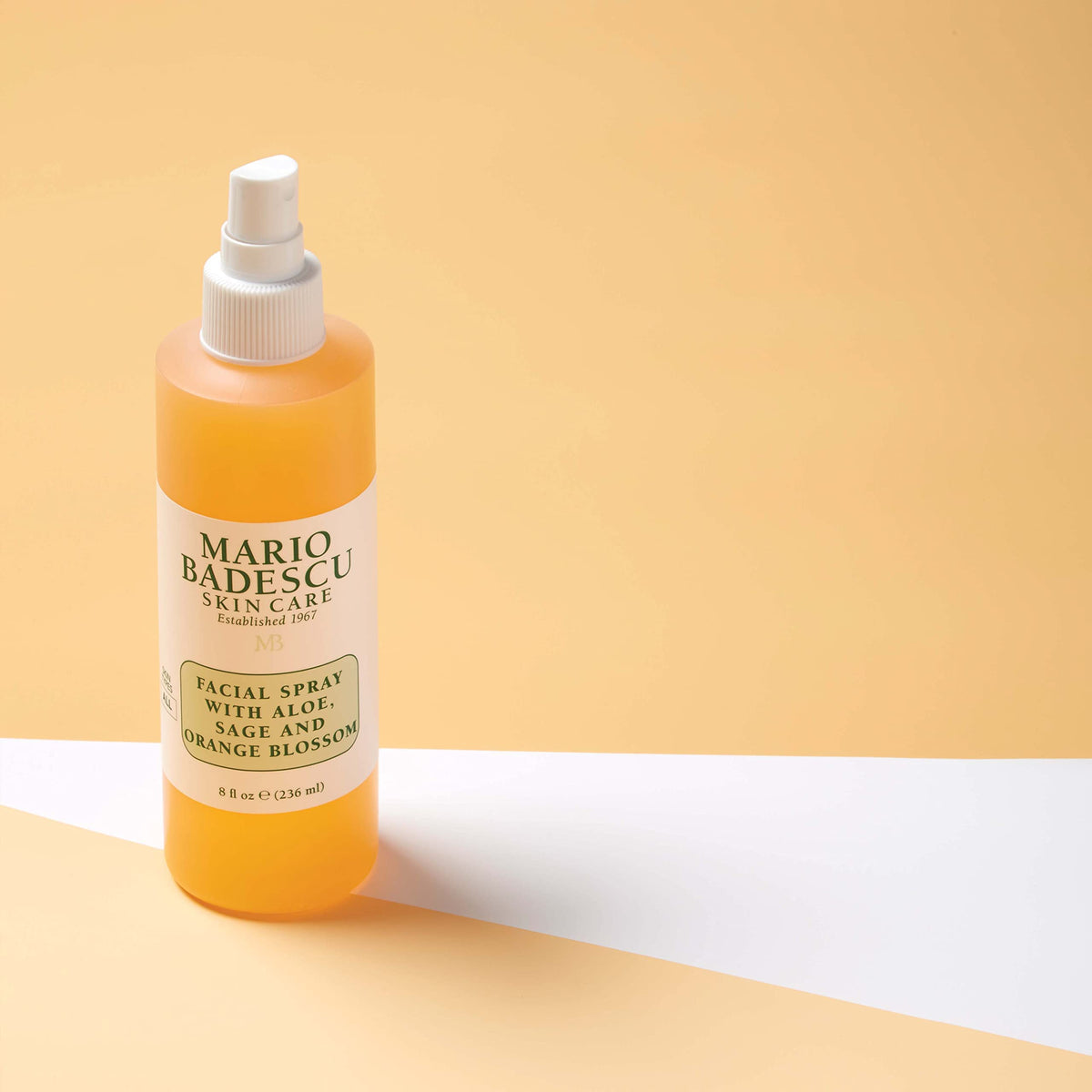 Mario Badescu bottle beside orange blossom and seaweed showing natural actives