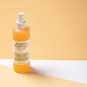 Mario Badescu bottle beside orange blossom and seaweed showing natural actives