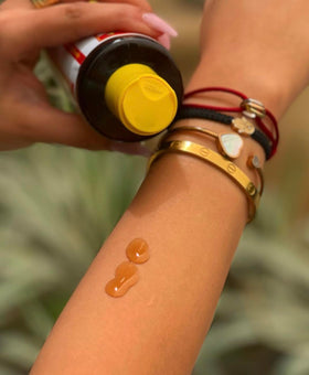 Applying Maui Island Secret on forearm to accelerate tanning and moisturize skin
