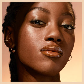 Maybelline Lifter Gloss on a vanity with makeup tools, ready for everyday use