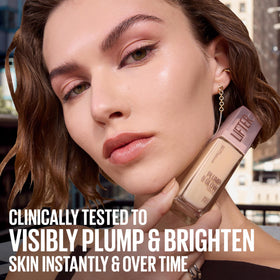 Maybelline Lifter bottle beside hand to show true size and travel-friendly benefit
