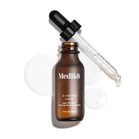 Medik8 C‑Tetra Luxe on a bathroom shelf styled with plants to suggest daily use