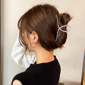 Mehayi clip held in hand for scale, shows size for thick long hair