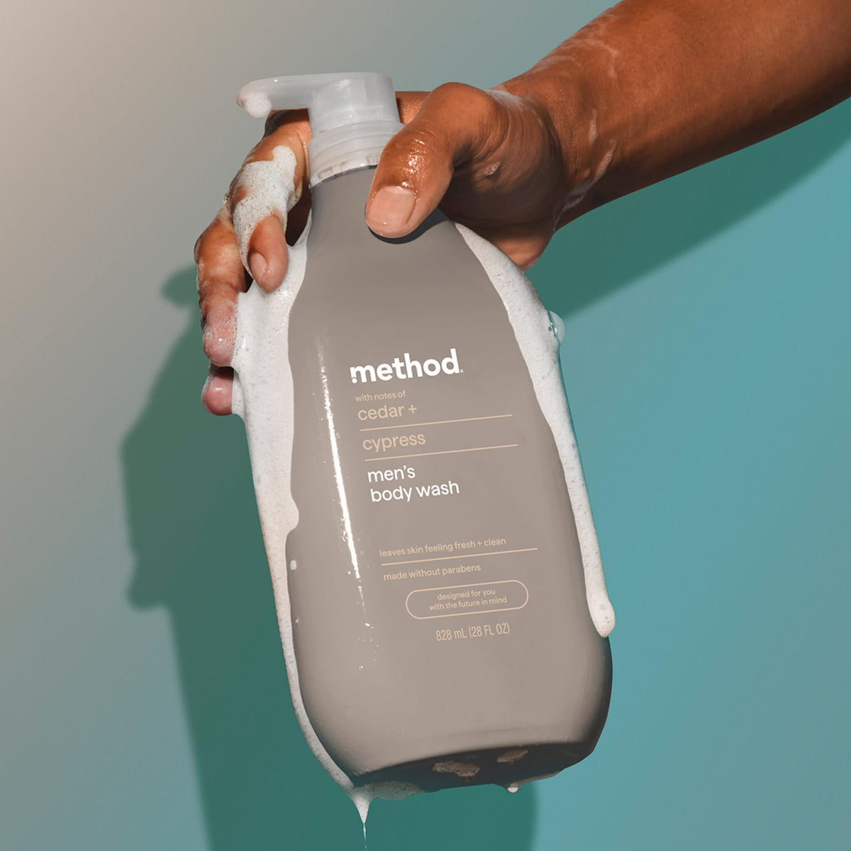 Method Men cedar and cypress bottle beside a hand for scale showing large 28 oz value