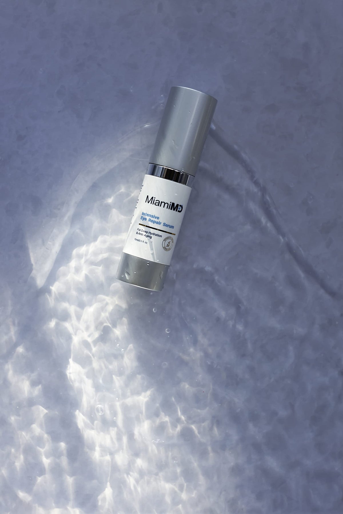 MiamiMD eye serum size scale beside coin showing compact 15ml travel-friendly
