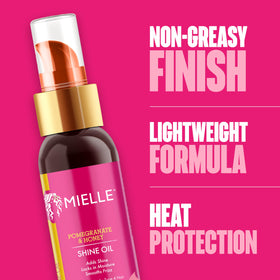 Mielle Organics bottle beside pomegranate and honey highlighting natural ingredients