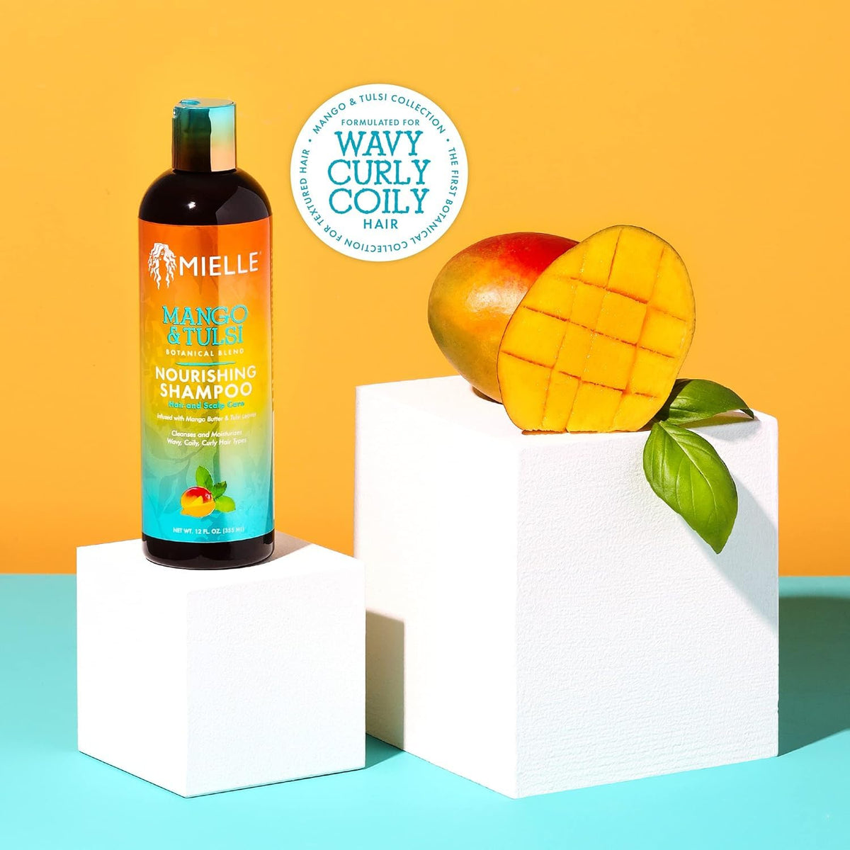 Mielle Organics bottle beside fresh mango showing nourishing ingredient