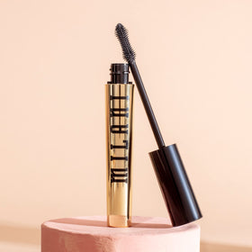 Milani mascara next to ruler scale showing compact tube size for travel benefit