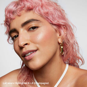 Milk Makeup Lit swiped on collarbones and shoulder, delivering all-over shimmer