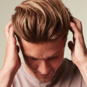 MITCH cream on fingertips, shows spreadable formula for quick volumizing benefit