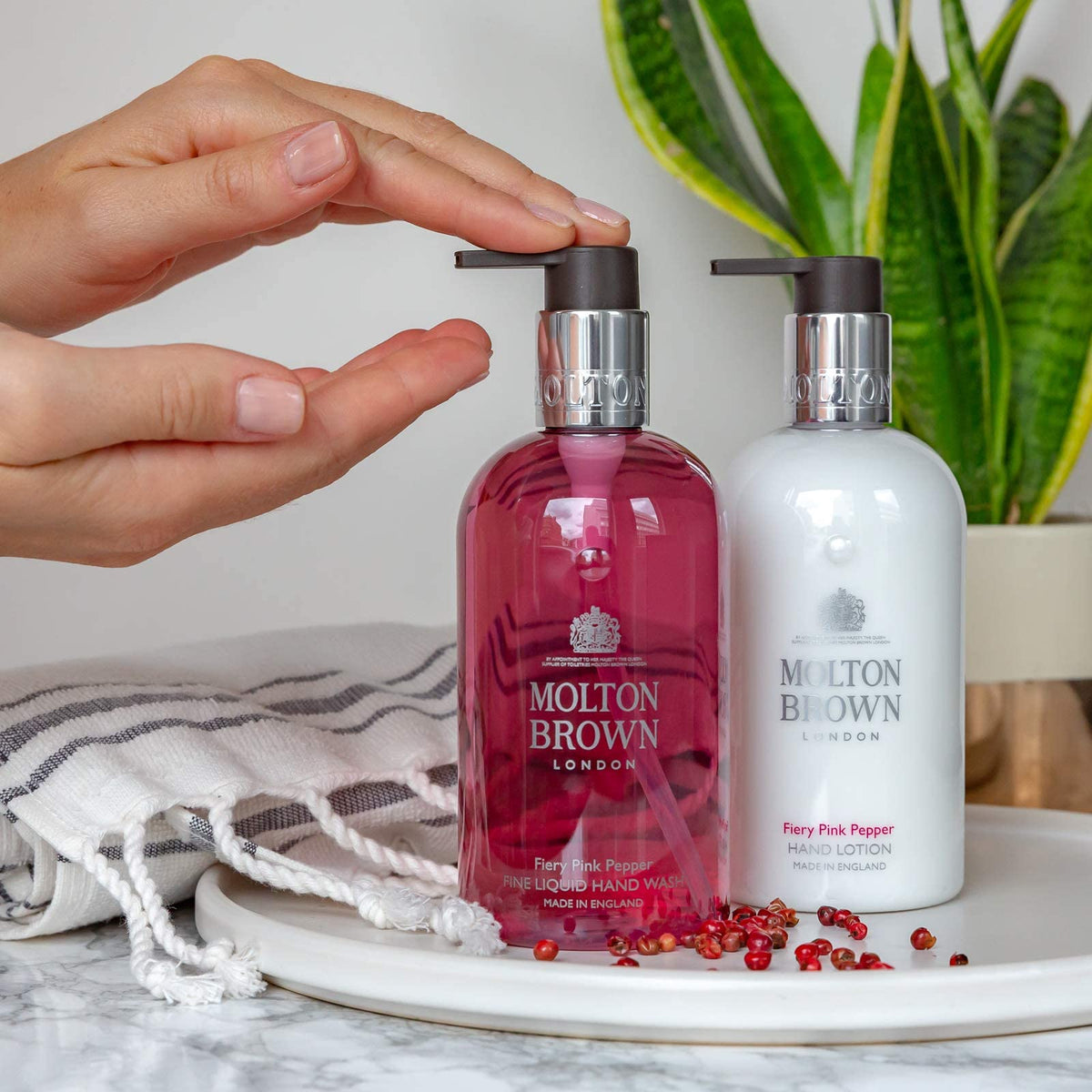 Molton Brown bottle beside a ruler to show 10 fl. oz. size and travel-ready benefit