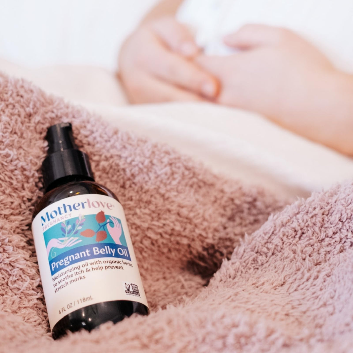 Rosehips and chamomile near Motherlove bottle illustrating natural botanical blend