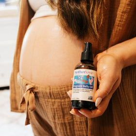 Pregnant person relaxing with Motherlove oil applied for calming skin comfort
