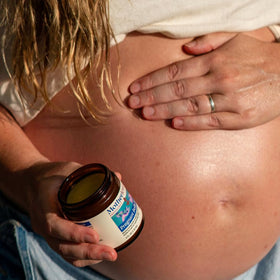 Motherlove applied to an expectant belly demonstrating gentle moisturizing