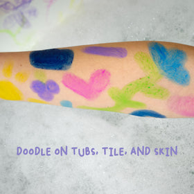 Mr. Bubble paint stick beside child-sized hand, shows kid-friendly grip and scale