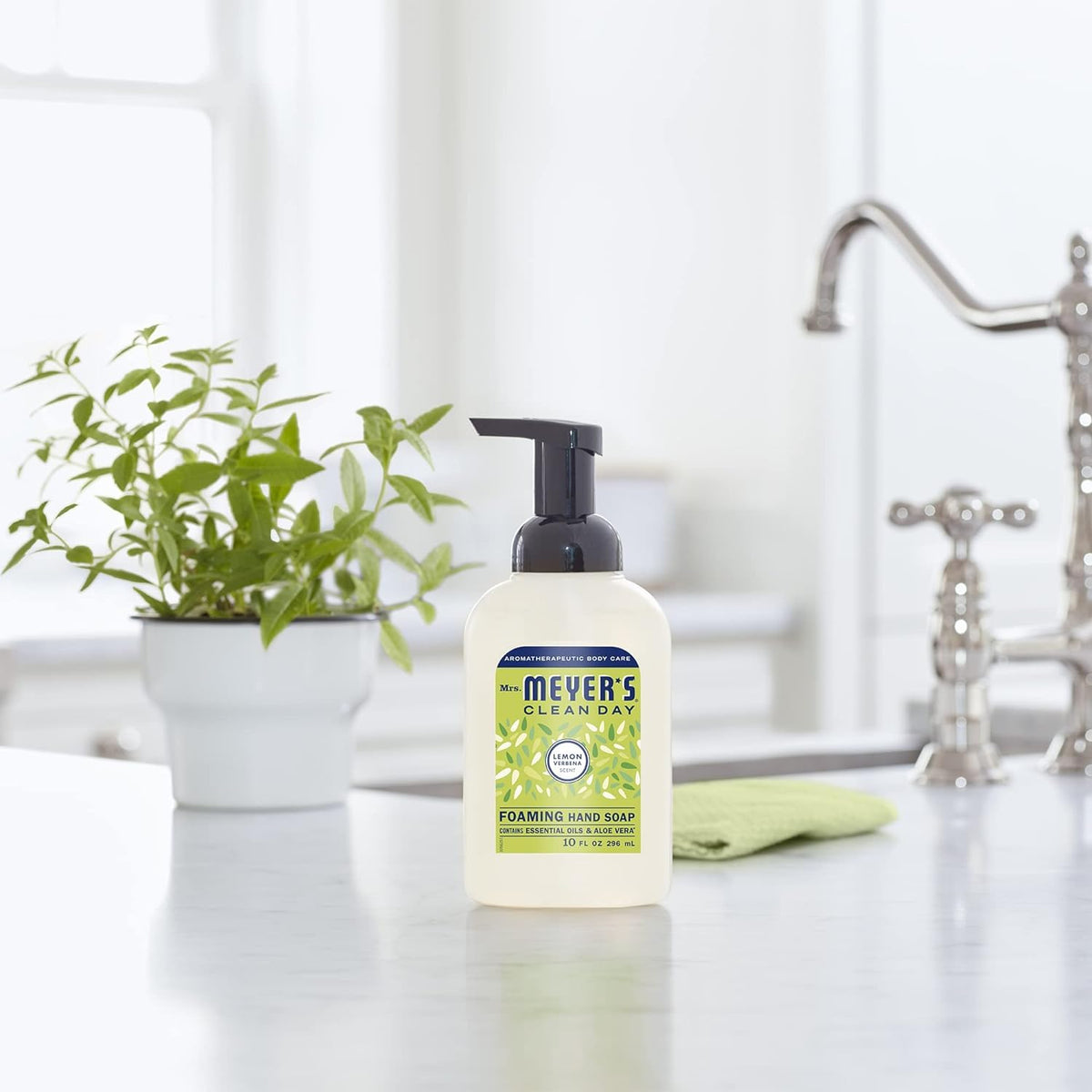 Mrs. Meyer's bottle beside a potted plant lifestyle scene suggesting natural ingredients