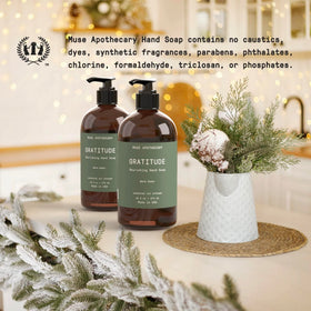 Muse Apothecary bottle next to a hand to show 16 oz scale and practical size