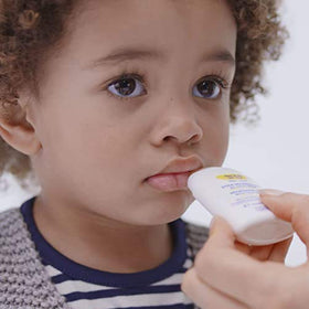 Mustela nourishing stick applied to baby cheek illustrating gentle soothing