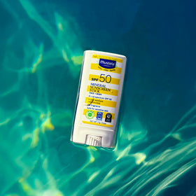 Mustela stick near water illustrating 80-minute water resistance for active days