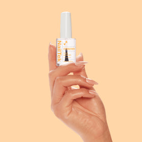 Nail Tek kit near a coin to show compact 0.5 fl oz size