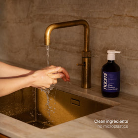 Naomi bottle beside a hand to show size and practical kitchen benefit