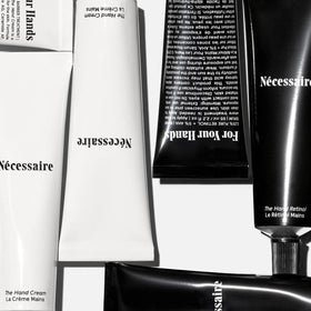Nécessaire hand retinol balm open on palm demonstrating balm texture and overnight repair