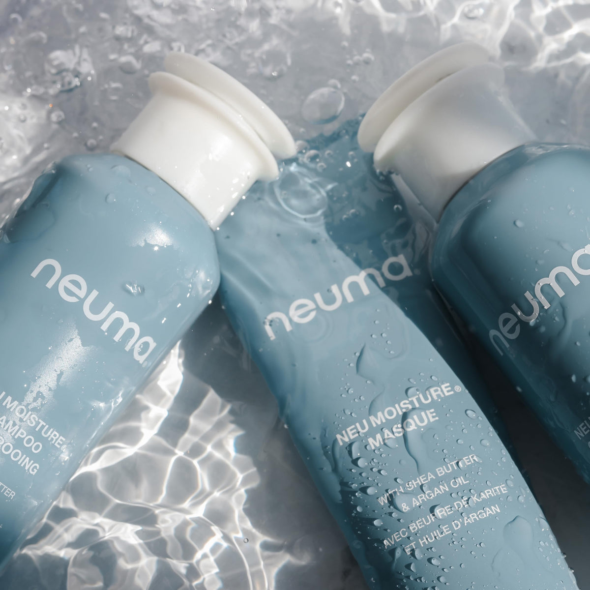 NEUMA open cap pouring shampoo to show pour control and consistency