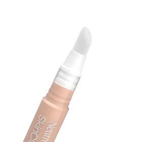 Neutrogena concealer next to coin for size comparison demonstrating travel-friendly portability
