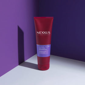 8.5 oz Nexxus bottle in hand to show true size and travel convenience