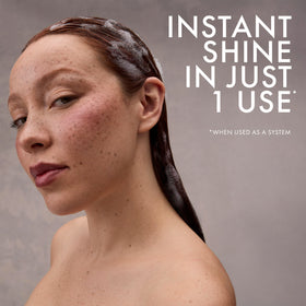 Person rinsing hair in shower using Nexxus for smoother color benefit