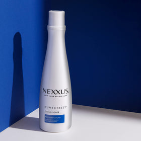 Nexxus bottles in hand indicating 13.5 oz size and travel-friendly benefit