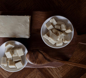 Nimba Foods wooden scoop of shea butter in bowl illustrating raw ingredient ready for recipes