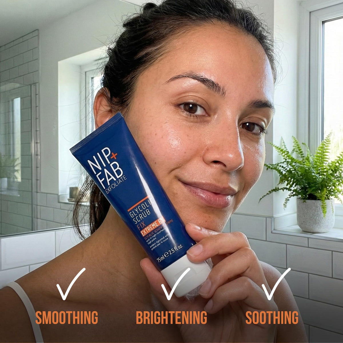 Hand holding 2.5 fl oz Nip+Fab tube to show compact travel-friendly size and convenience