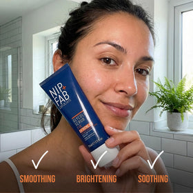 Hand holding 2.5 fl oz Nip+Fab tube to show compact travel-friendly size and convenience