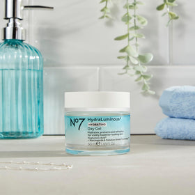 No7 next to a coin for size comparison to show compact 1.69 fl oz travel-friendly benefit